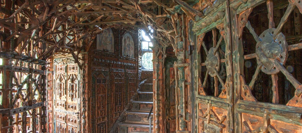 Foto des Inneren des Junkerhauses. Türen, Wende und Treppen scheinen nur aus Holz zu bestehen. Alles ist kunstvoll und filigran geschnitzt. Holzstäbe bilden teils kunstvolle Gerüste, durch die Licht Feld, Das Holz trägt sanfte natürliche Farbe.