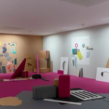 Austellungsraum mit pinkem Teppich und zwei Wänden, an denen sich abstrakte, flache bunte Objekte befinden. Mittig sowie vor den Wänden stehen diverse Kartons und Pappobjekt, die wild angeordnet sind.