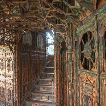 Foto des Inneren des Junkerhauses. Türen, Wende und Treppen scheinen nur aus Holz zu bestehen. Alles ist kunstvoll und filigran geschnitzt. Holzstäbe bilden teils kunstvolle Gerüste, durch die Licht Feld, Das Holz trägt sanfte natürliche Farbe.