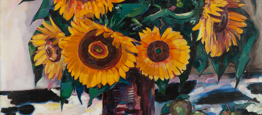 Gemälde im Hochformat. Mit kräftigen Farben ist ein Stillleben aus einem Sonnenblumen-Strauß in einer Vase auf einem Tisch mit weiß-schwarz gefleckter Tischdecke zu sehen. Um die Vase herum liegen kleine Äpfel und Kartoffeln.