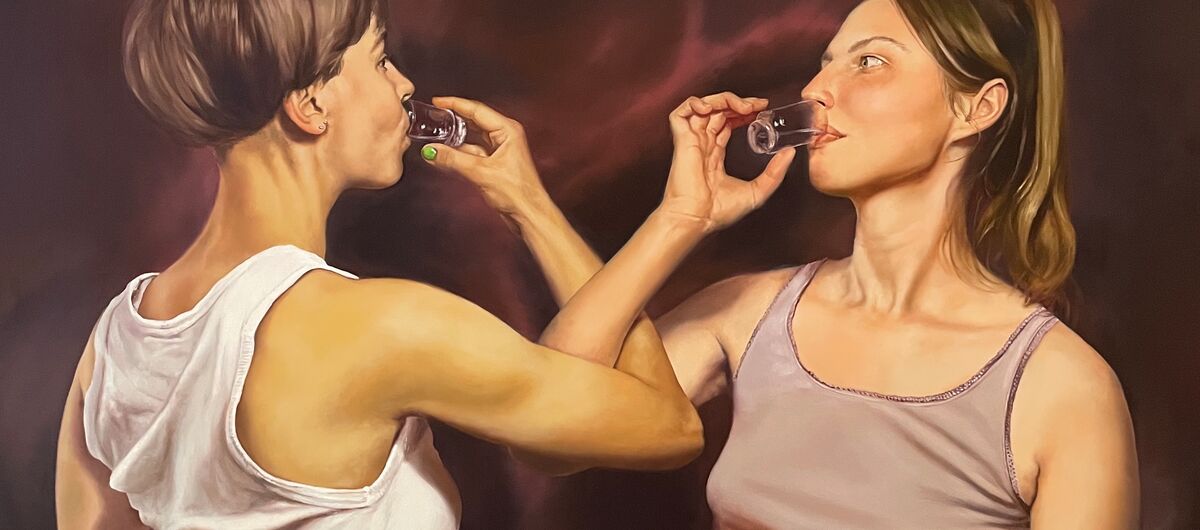 Das Gemälde wirkt wie ein Foto. Zwei schlanke Frauen in ärmellosen Tops haken ihre Arme ineinander und trinken beide aus Schnapsgläsern. Die linke Frau steht leicht mit dem Rücken zur betrachtenden Person und hat kurze Haare, die rechte einen Zopf.