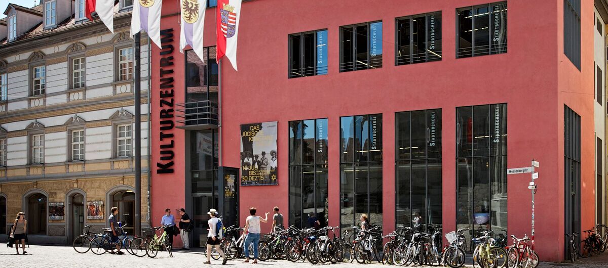 Foto der Außenansicht der Städtischen Wessenberg-Galerie im Kulturzentrum. Das Haus ist in einem braun-rot gestrichen. Neben der Eingangstür zieren vier hohe Fenster im Erdgeschoss und vier kleine Fenster darüber die Fassade.