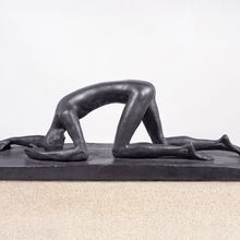 Foto einer Bronze-Figur in einheitlichem Schwarz. Ein großer dünner nackter Mensch ist auf allen vieren auf einem niedrigen Sockel. Er schützt sich auf den Unterarmen und mit dem Kopf ab. Die Beine knien leicht versetzt.