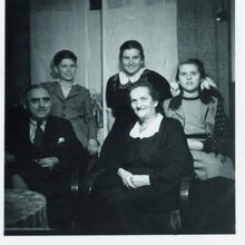 Foto eines alten schwarz-weiß Fotos. Abgebildet sind fünf freundlich schauende und gut gekleidete Menschen. Im Vordergrund sitzend rechts ein Mann und links eine Frau. Hinter ihnen stehen ein Junge und zwei Mädchen, vermutlich im Teenageralter.